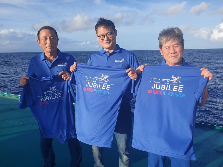 남태평양에서 조업중인 김민호 동원산업 주빌리호 선장(가운데)과 선원들이 '플라스틱 저감화 3개년 계획'의 슬로건 “No! Plastic! Yes! Blue Ocean!”이 적힌 티셔츠를 들고있다.